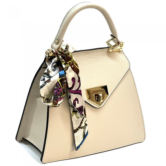 A red leather handbag with gold-tone metal details and a decorative scarf attached to the handle.