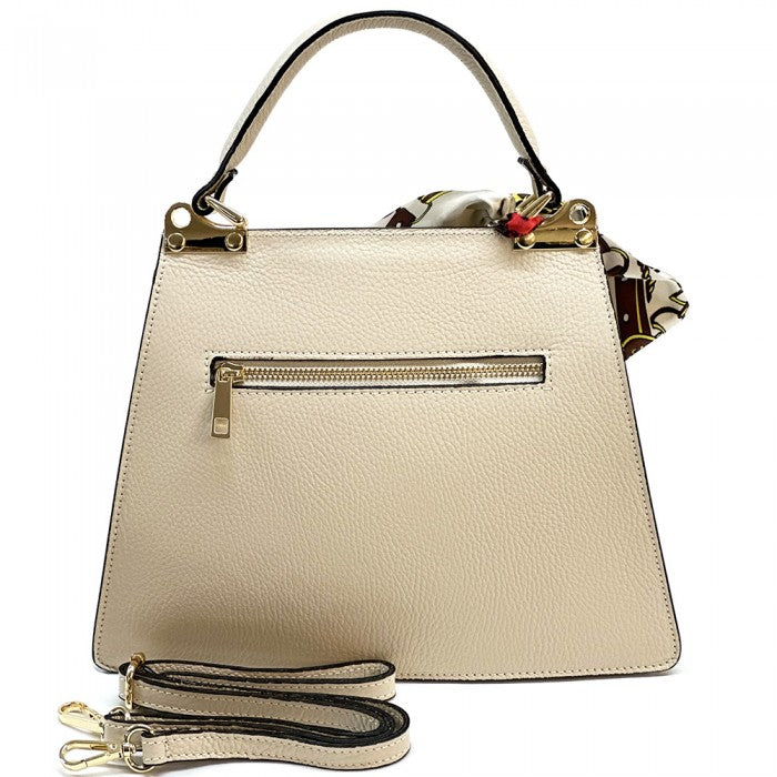 A red leather handbag with gold-tone metal details and a decorative scarf attached to the handle.