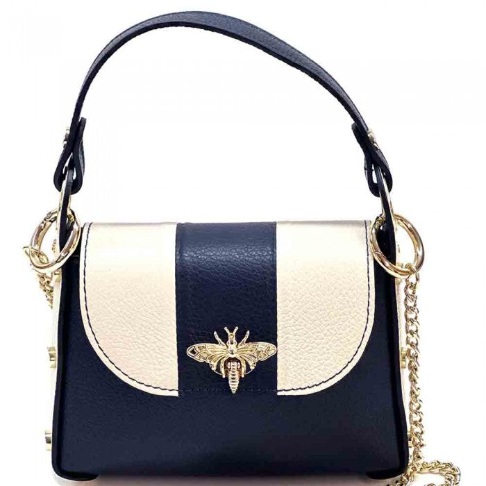 A black and white leather handbag with a gold bee metal embellishment, featuring a structured silhouette and a metal chain strap.