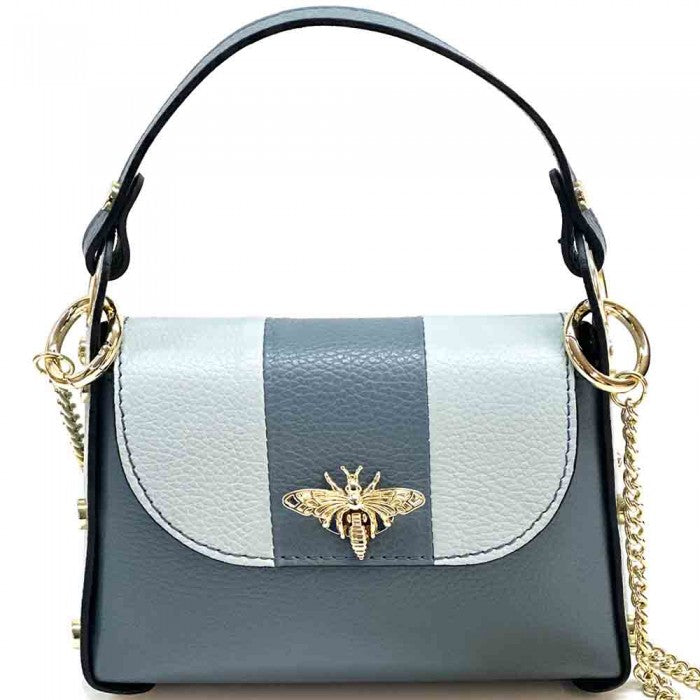 A black and white leather handbag with a gold bee metal embellishment, featuring a structured silhouette and a metal chain strap.