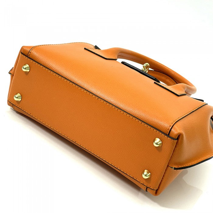 A Italian leather handbag with a structured design, double handles, and a gold-tone clasp.