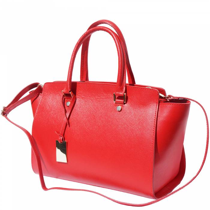 A red leather handbag with golden metal hardware and a decorative tag on one of the handles.