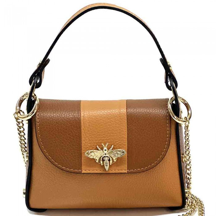 A black and white leather handbag with a gold bee metal embellishment, featuring a structured silhouette and a metal chain strap.